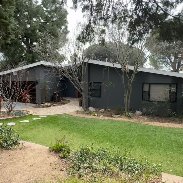 Video: single-story home with a glass-paneled bifold garage door behind a new lawn